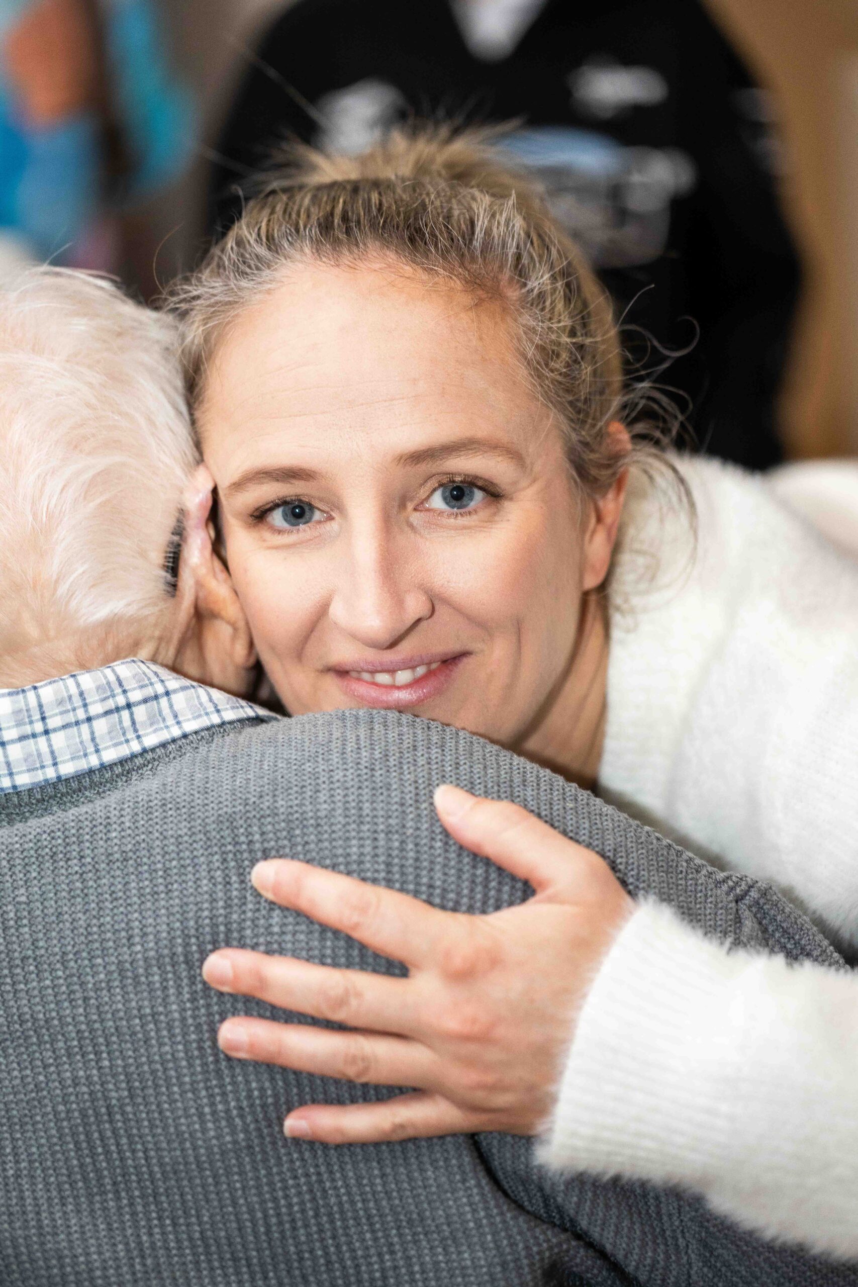 Candid portrait of a young woman cuddling an old man