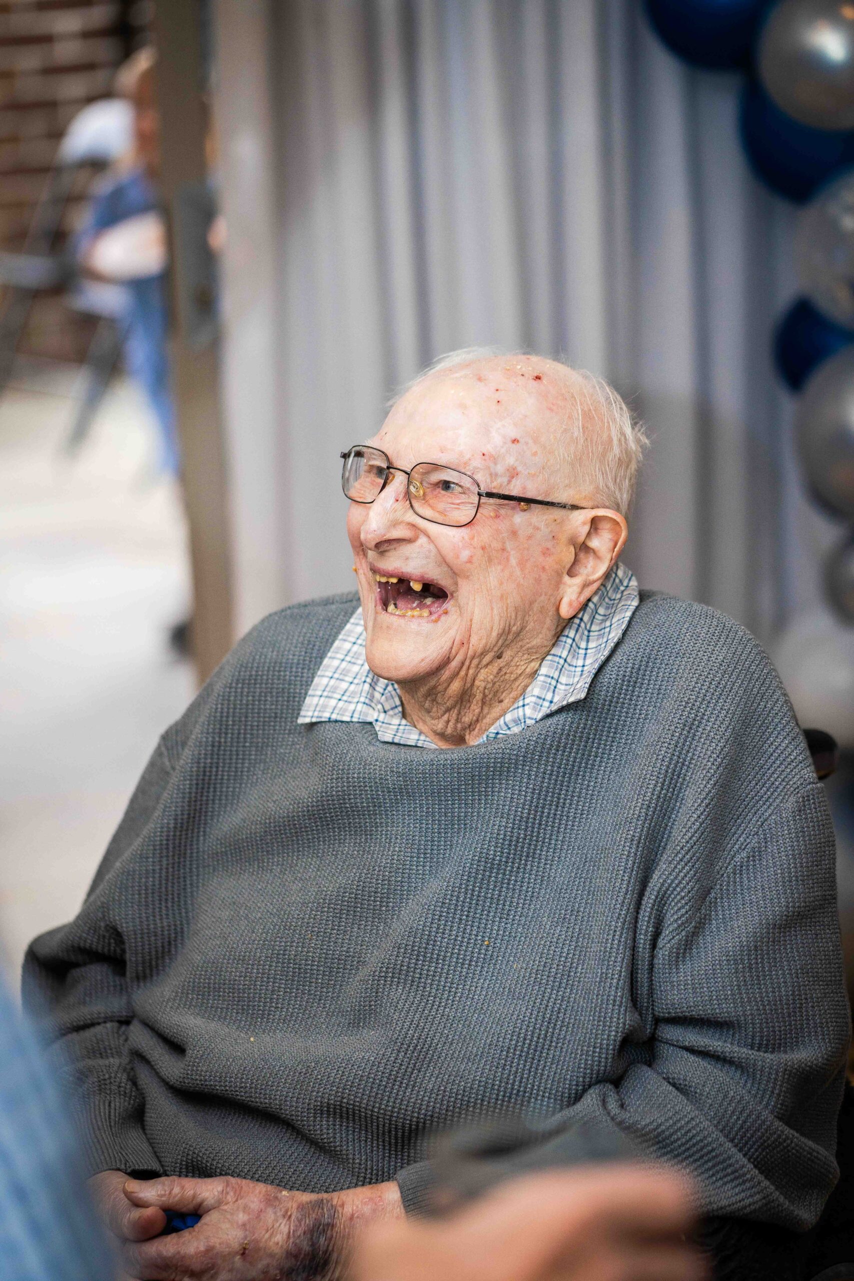 Candid portrait of old man laughing at a birthday party
